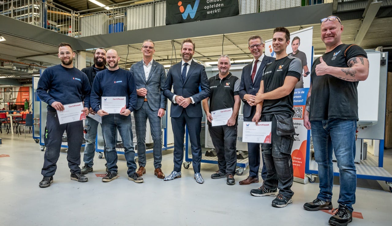 Minister De Jonge met de monteurs die de eerste deelcertificaten hebben ontvangen.