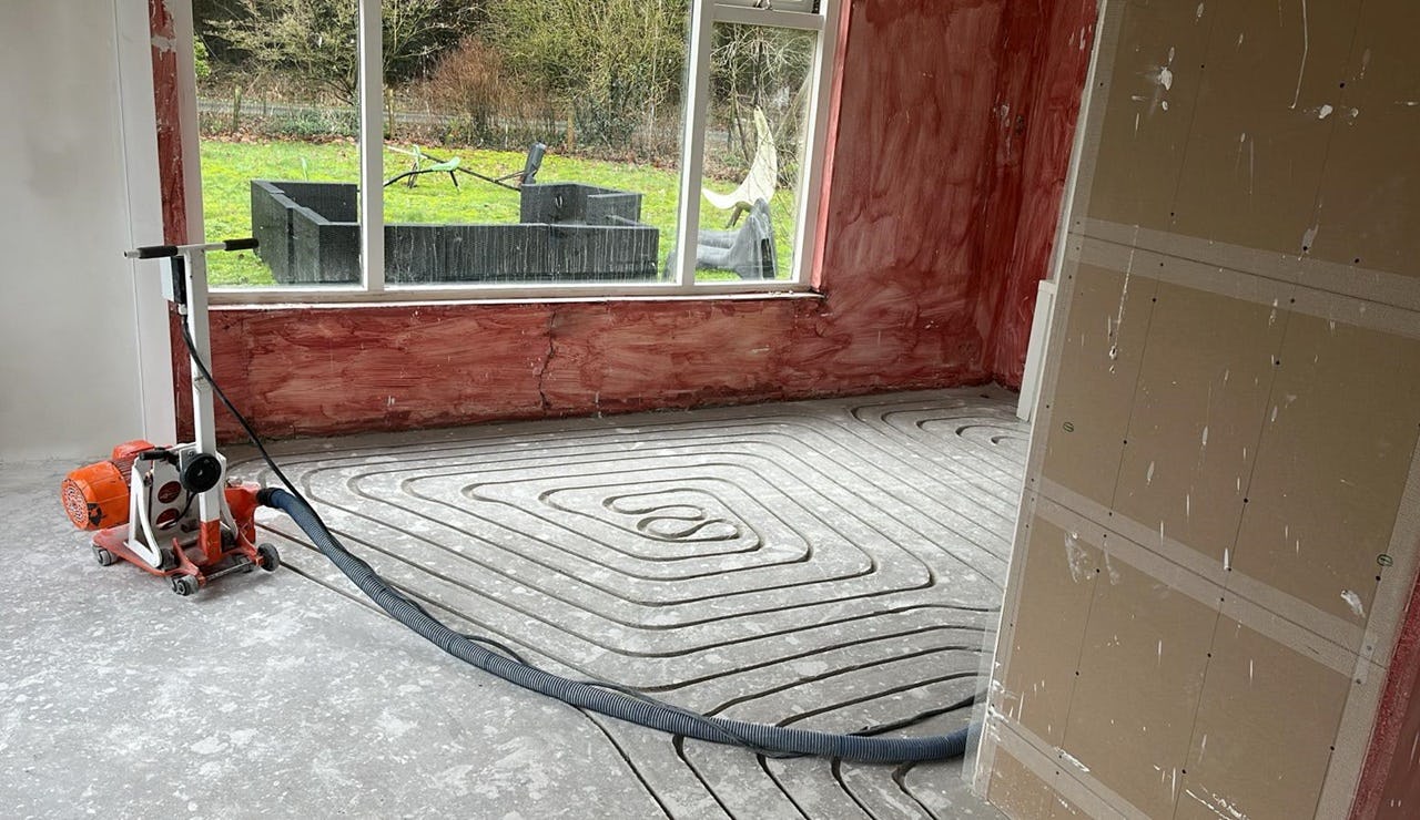 Freesmachine, met erop aangesloten een slang die stof afvoert.