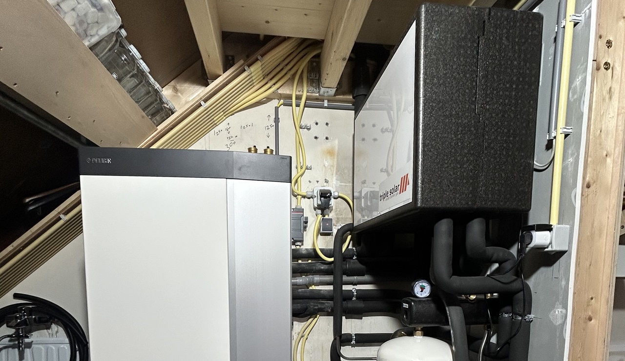 Op zolder staat de warmtepomp (links), naast de koelmodule van het PVT-systeem.