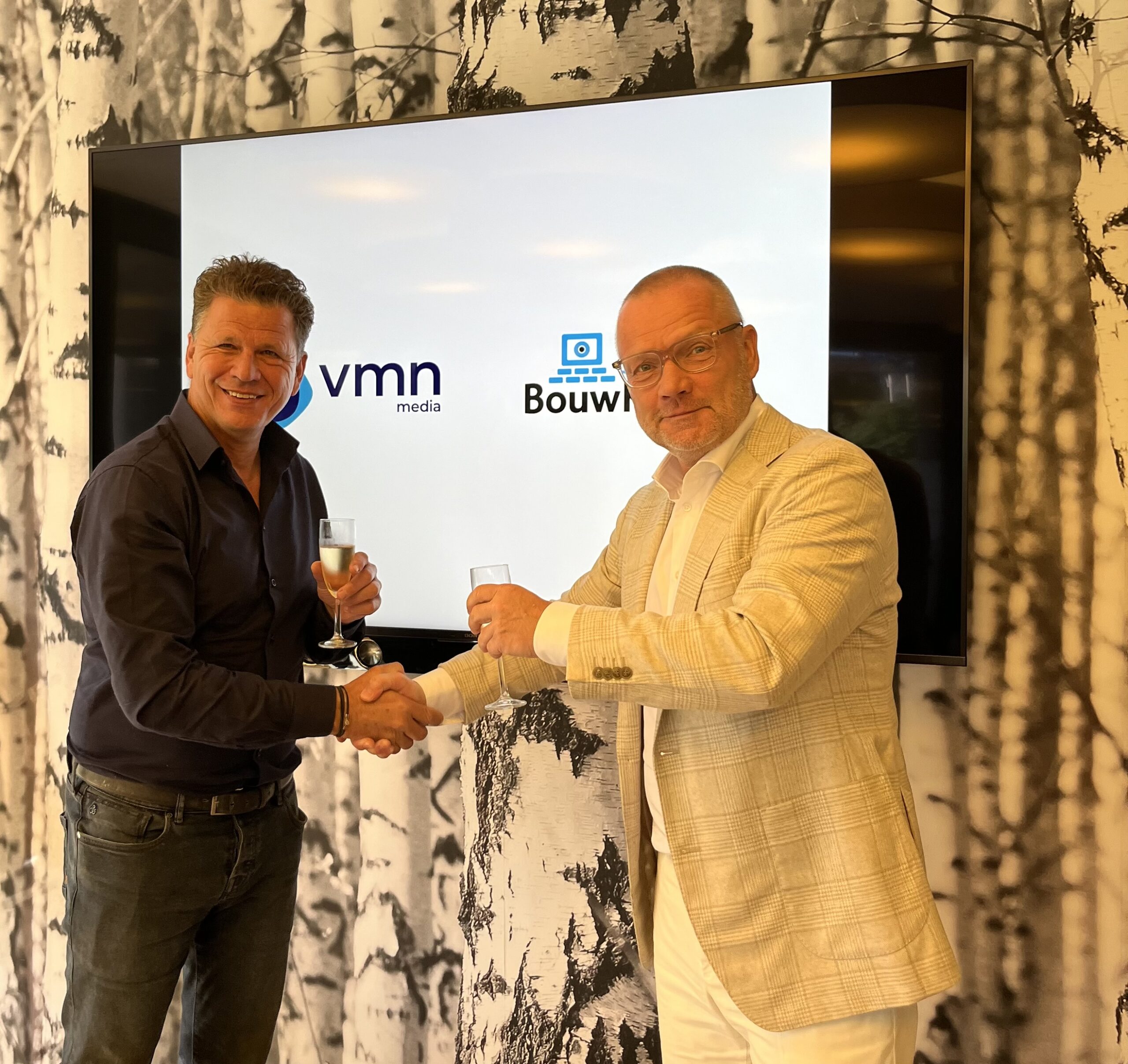 Erik Hoekstra, CEO VMN media (links) en Jan-Paul Schop, CEO USP Marketing Consultancy en oud eigenaar / oprichter BouwKennis heffen na de ondertekening van de overname het glas.  
