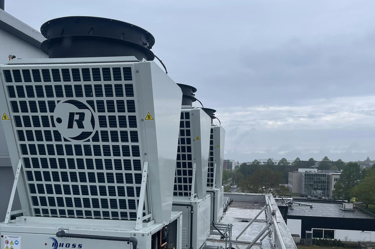 Propaanwarmtepompen uit de Poker-serie van Rhoss op het dak van een gebouw.