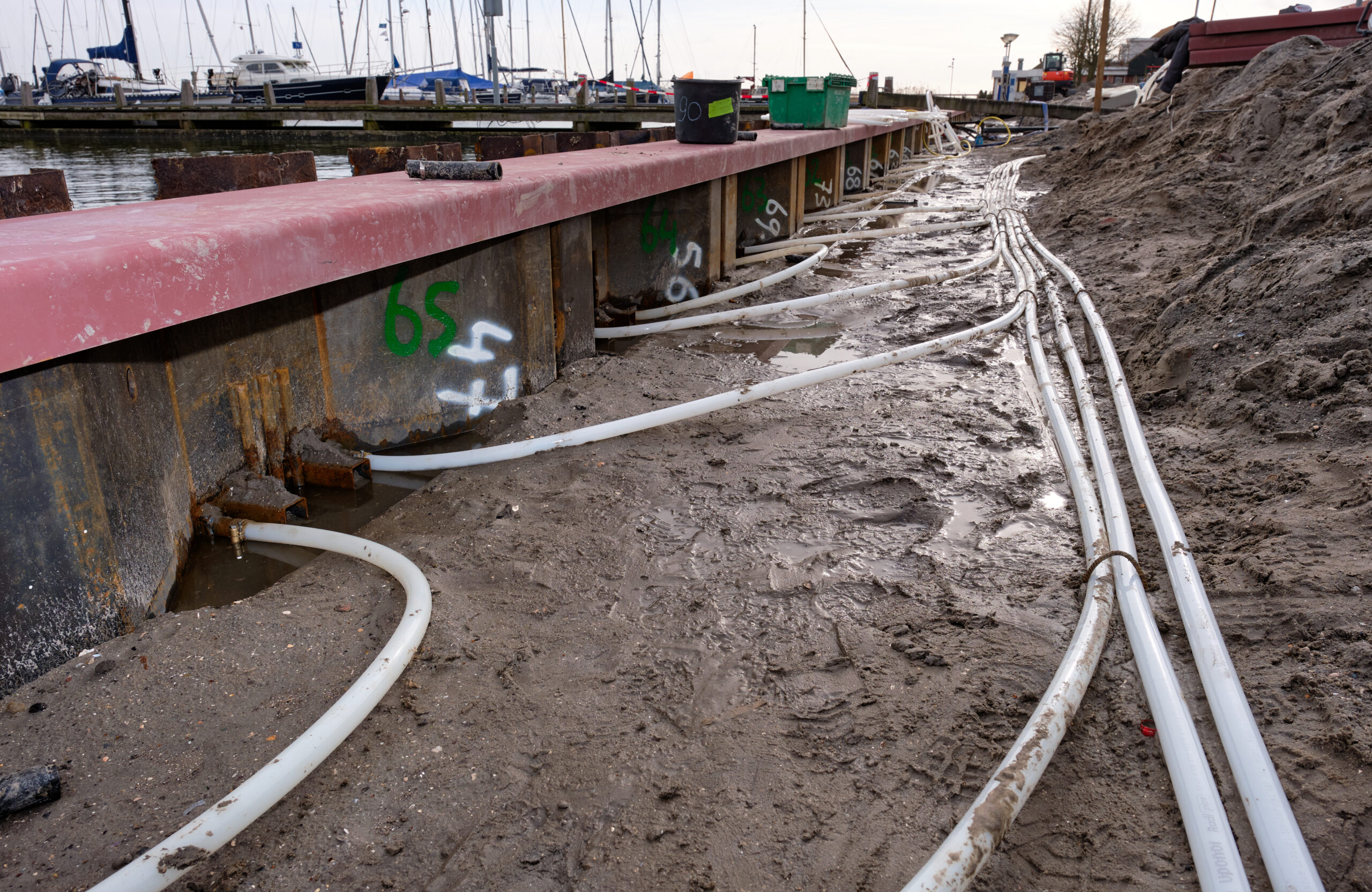 Foto van een Energiedamwand in aanleg. De witte leidingen verbinden de lussen in de damwand met een centraal verdeelpunt. © www.lagro-fotografie.nl