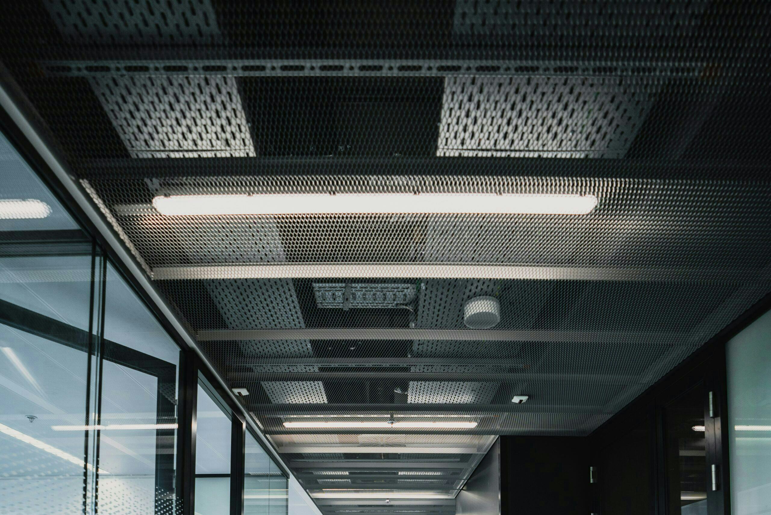 Hal met modules zichtbaar aan het plafond. Deze kant-en-klare kooiconstructies van montagerails met leidingen worden in de prefab-werkplaats in Hengelo gemaakt.