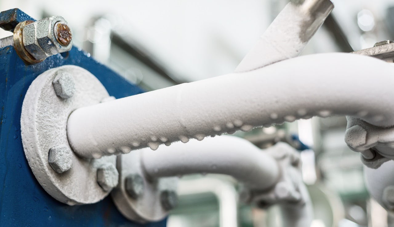 Bevroren condens op de leiding van een koelmachine.