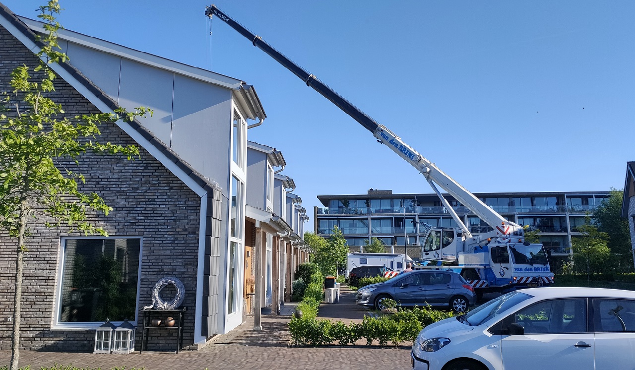 In Voorthuizen worden buitenunits met een kraan van het dak gehaald. 