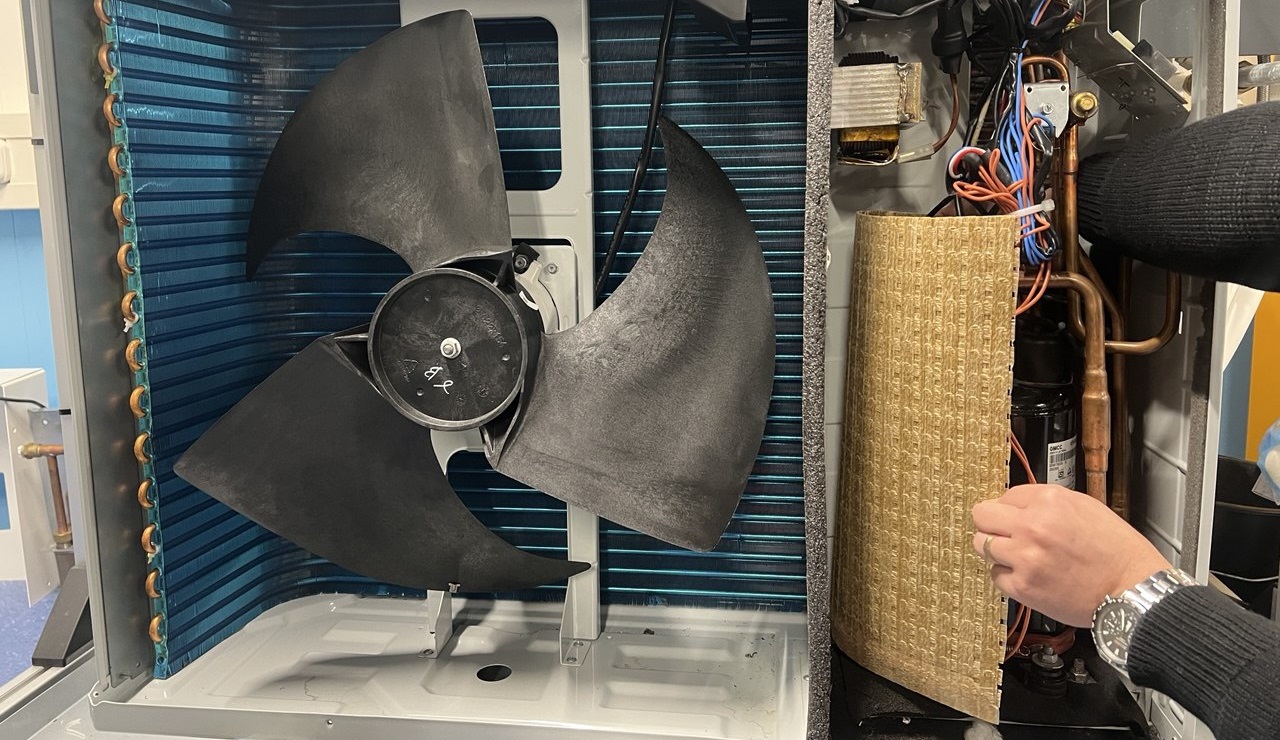 De ‘acoustic compressor jacket’-mantel kan om de compressor worden gewikkeld, waardoor de kleine gaatjes in het materiaal het geluid ervan opvangen.