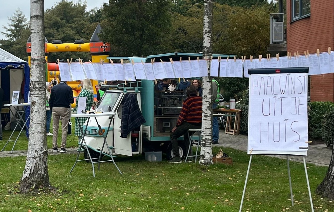 De burendag in Krommenie met een waslijn waaraan A4tjes hangen met beschrijvingen van verduurzaamde woningen in de buurt.