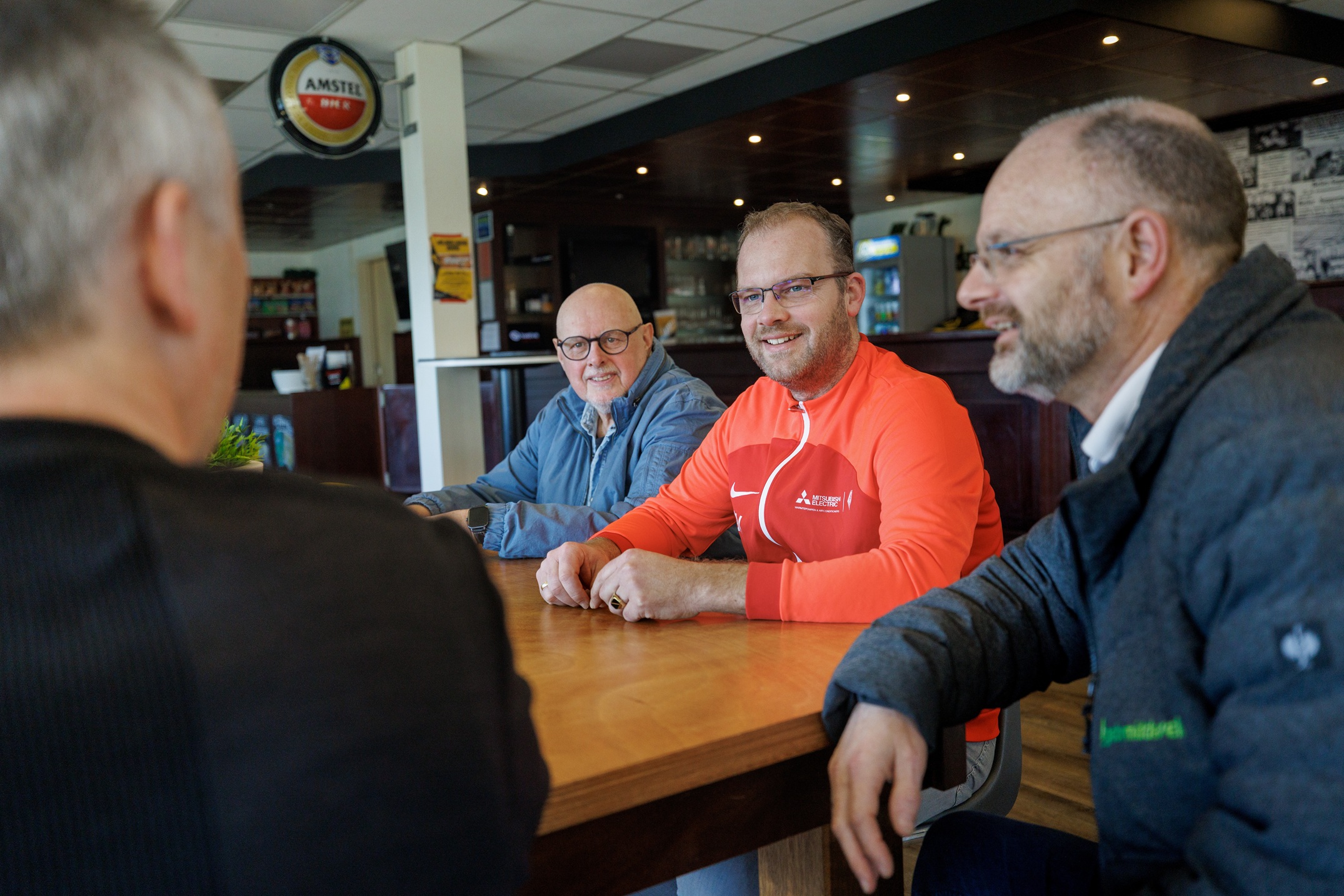 Clubexpert Gert aan tafel met clubbestuurders over de verduurzaming van het sportcomplex.