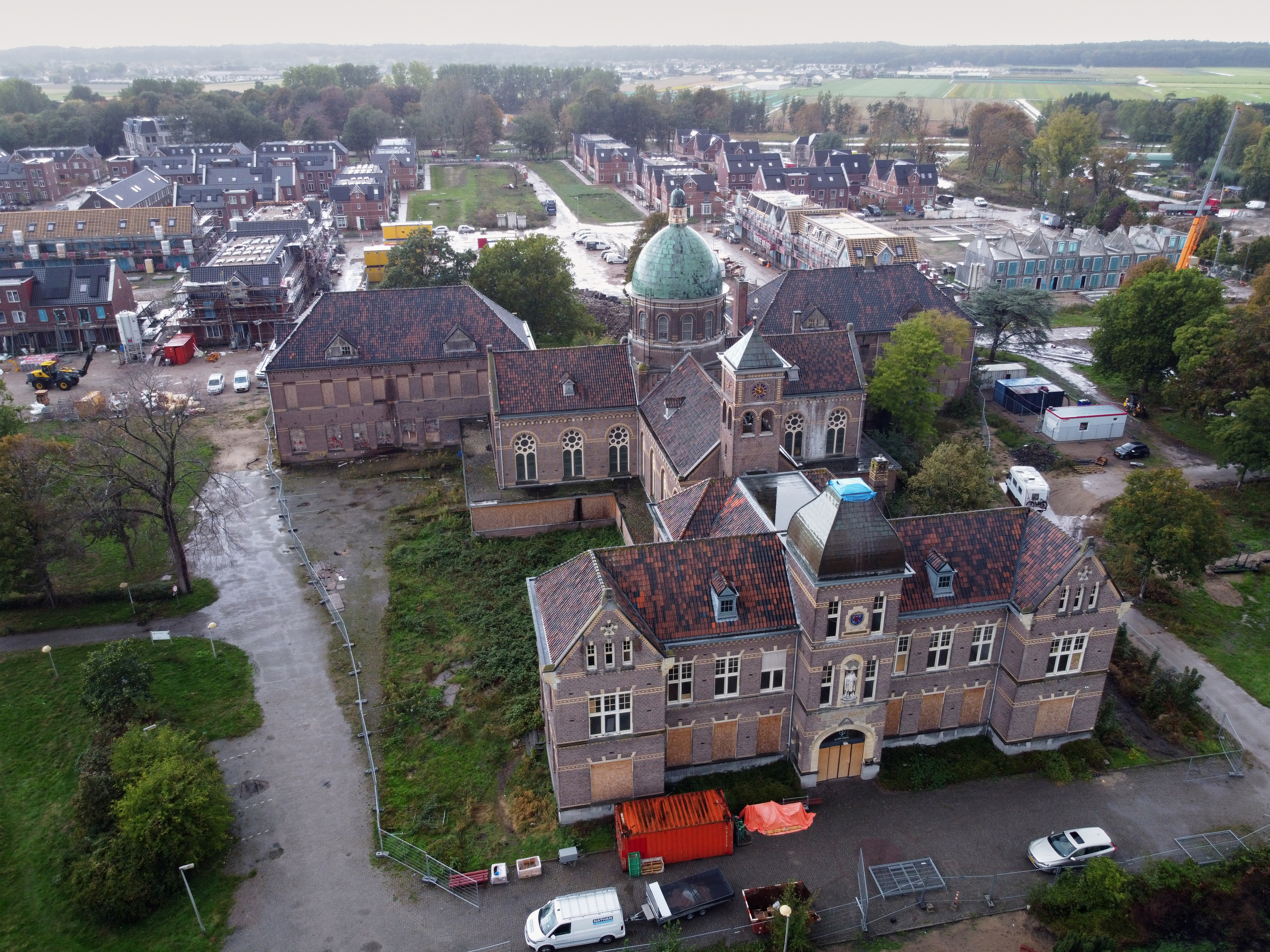 Nieuwbouwwijk In de Houte (op de achtergrond), waarvan de woningen met een ZLT-warmtenet worden verwarmd en gekoeld. Op de voorgrond het Bavo-gebouw, waarin appartementen komen die ook op het warmtenet worden aangesloten. In het gebouw bevindt zich de technische ruimte van het warmtenetsysteem. Foto: Nathan.