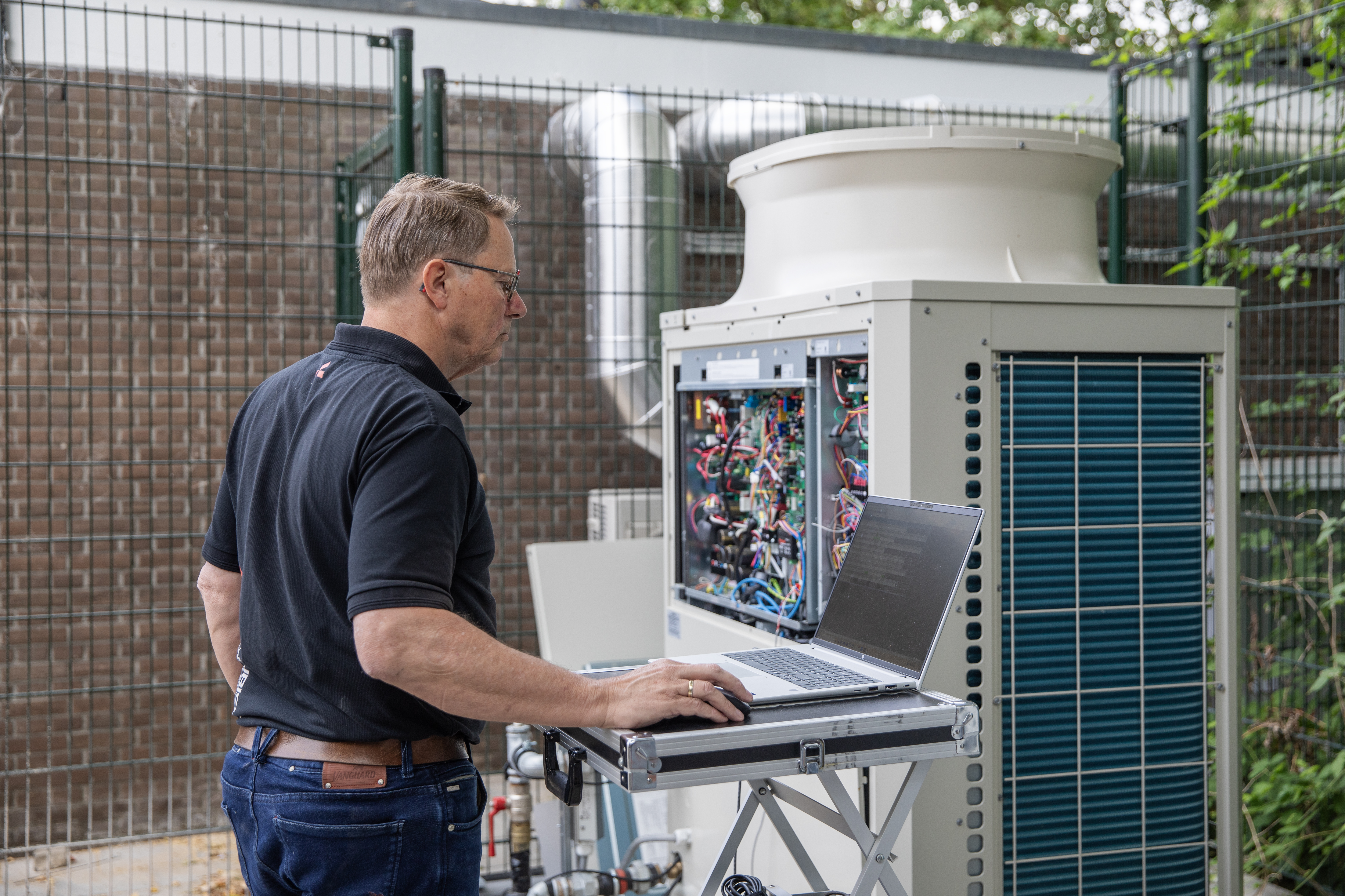 Jeroen van den Akker van Alklima stelt de CO2-warmtepomp in bedrijf.