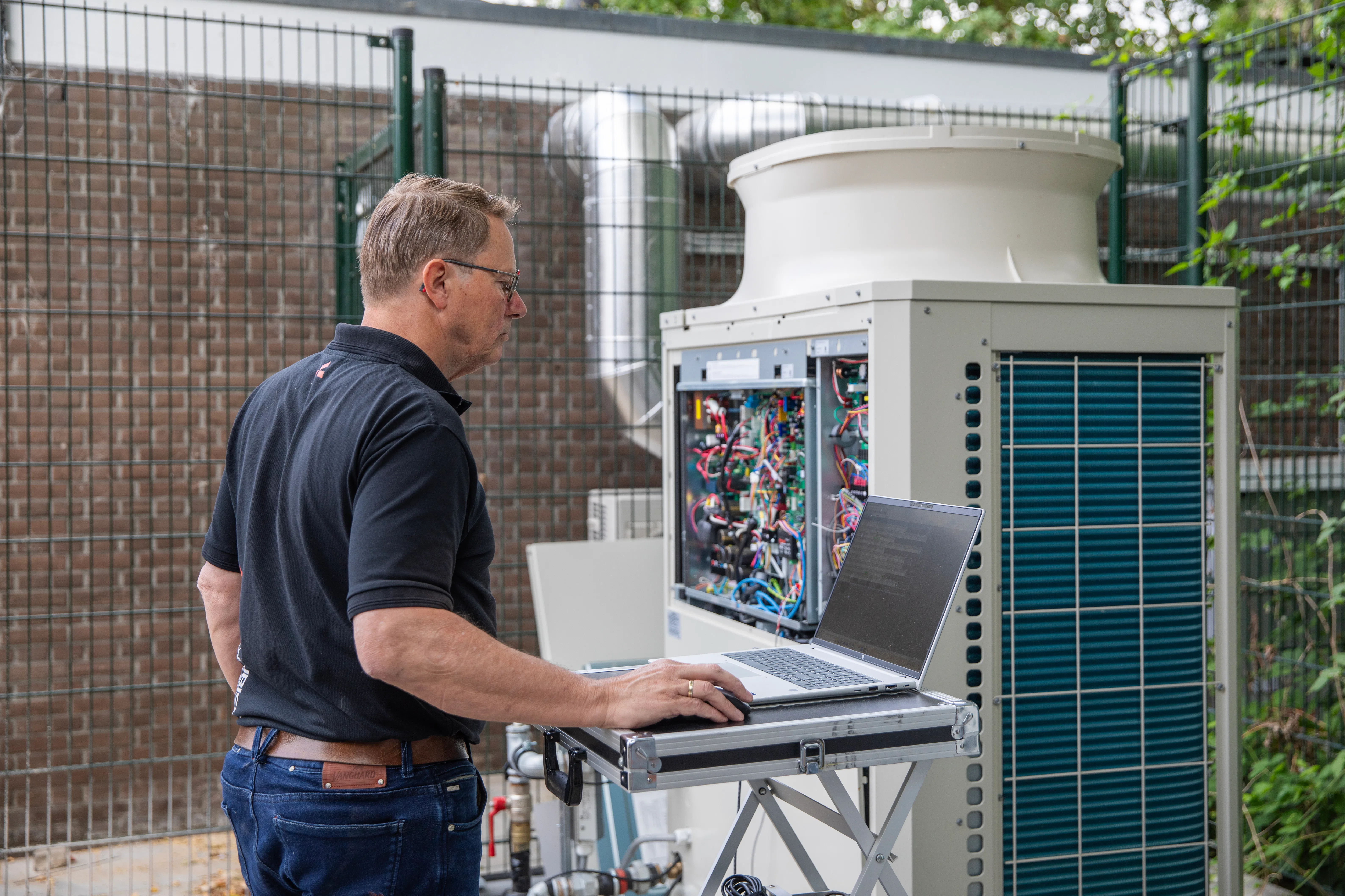 Jeroen van den Akker van Alklima stelt de CO2-warmtepomp in bedrijf.