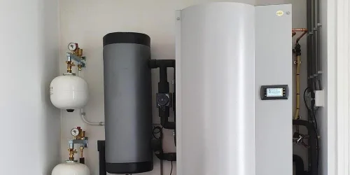 Een bodemwarmtepomp met buffervat in de technische ruimte van een woning. Het systeem is onzichtbaar, stil en goed weg te werken.