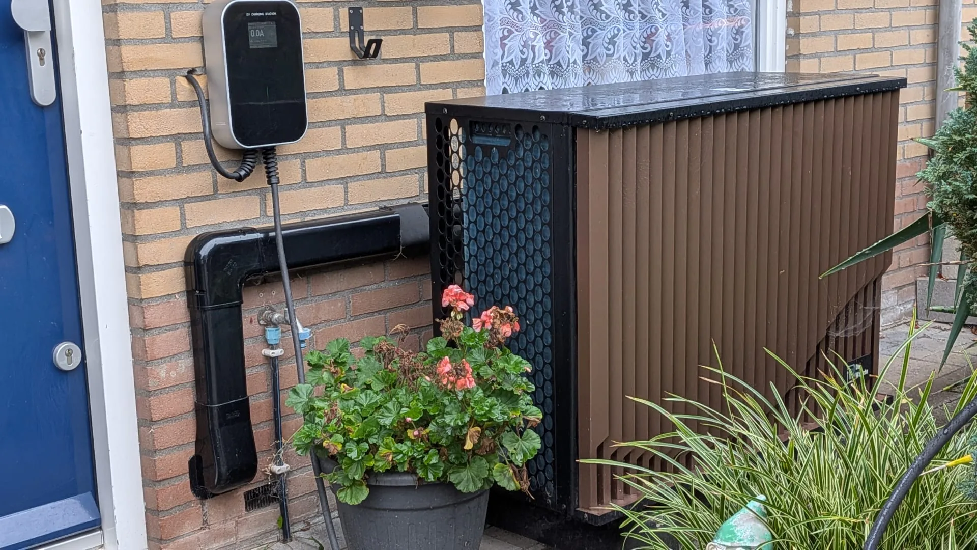 Een warmtepomp van DeWarmte die parallel aan de andere kant van de muur op de cv-installatie is aangesloten.